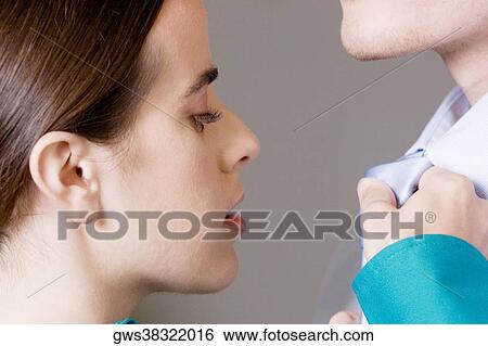 Stock Photograph - Close-up of a businesswoman adjusting a businessman's tie. Fotosearch