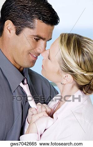 Stock Photography - Close-up of a businesswoman adjusting a businessman's tie. Fotosearch