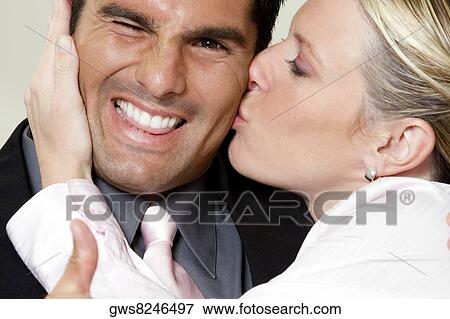Stock Photo - Close-up of a businesswoman kissing a businessman. Fotosearch
