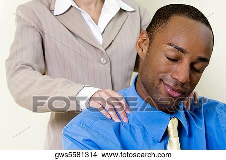Picture - Close-up of a businesswoman massaging a businessman's shoulder. Fotosearch