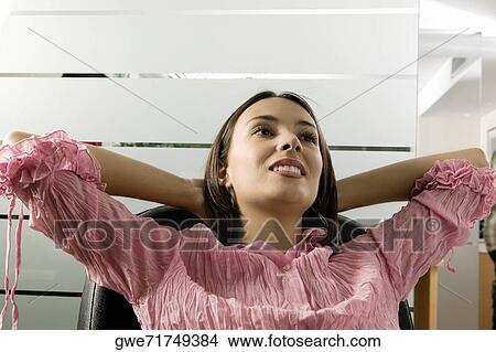Close-up of a businesswoman sitting on a chair View Large Photo Image Picture - Close-up of a businesswoman sitting on a chair. Fotosearch