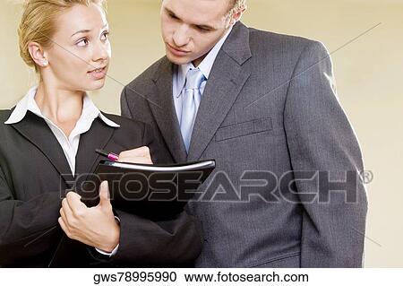 Stock Image - Close-up of a businesswoman talking to a businessman. Fotosearch