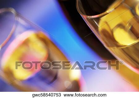 Stock Image - Close-up of a champagne bottle with champagne in two champagne flutes. Fotosearch