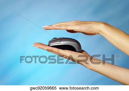 Stock Photography - Close-up of a computer mouse on a woman's hands. Fotosearch