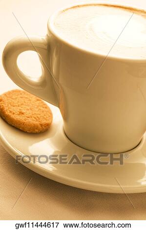 Close-up of a cup of coffee served with a cookie View Large Photo Image Stock Photo - Close-up of a cup of coffee served with a cookie. Fotosearch