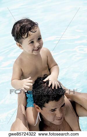 Close-up of a father carrying his son on his shoulders in a swimming pool View Large Photo Image Stock Image - Close-up of a father carrying his son on his shoulders in a swimming pool. Fotosearch