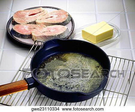 Close-up of a frying pan on a cooling rack with salmon beside it View Large Photo Image Picture - Close-up of a frying pan on a cooling rack with salmon beside it. Fotosearch
