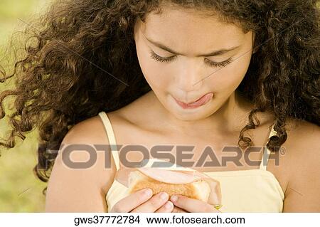 Close-up of a girl holding a burger View Large Photo Image Picture - Close-up of a girl holding a burger. Fotosearch