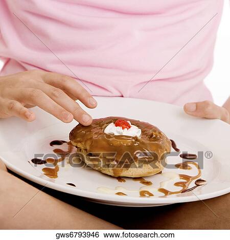 Close-up of a girl holding dessert in a plate View Large Photo Image Stock Photograph - Close-up of a girl holding dessert in a plate. Fotosearch