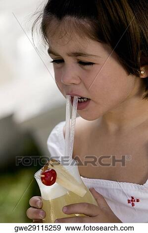 Close-up of a girl sipping drink from a glass View Large Photo Image Stock Photo - Close-up of a girl sipping drink from a glass. Fotosearch