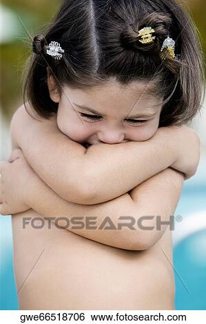 Stock Photograph - Close-up of a girl with crossed arms smiling. Fotosearch