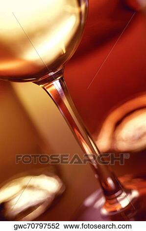 Stock Image - Close-up of a glass of wine with two wine bottles. Fotosearch