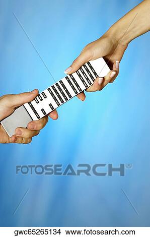 Close-up of a man and a woman's hands holding a remote control View Large Photo Image Picture - Close-up of a man and a woman's hands holding a remote control. Fotosearch