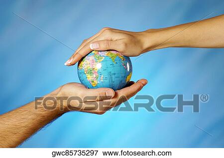 Close-up of a man and a woman's hands holding a globe View Large Photo Image Stock Photo - Close-up of a man and a woman's hands holding a globe. Fotosearch
