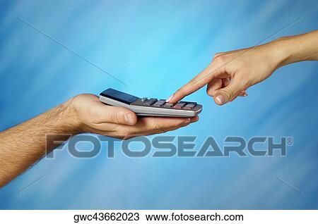 Stock Image - Close-up of a man holding a calculator with a woman's finger pressing a button. Fotosearch