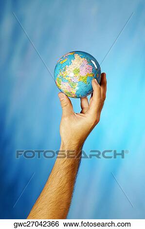 Stock Photograph - Close-up of a man's hand holding a globe. Fotosearch