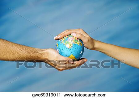 Close-up of a man's hand holding a globe with a woman's hand above it View Large Photo Image Stock Image - Close-up of a man's hand holding a globe with a woman's hand above it. Fotosearch