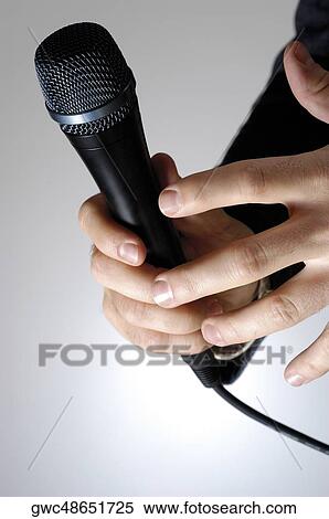 Close-up of a man's hand holding a microphone View Large Photo Image Stock Photography - Close-up of a man's hand holding a microphone. Fotosearch