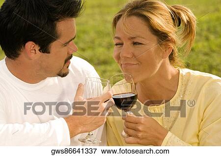 Close-up of a mature man and a young woman toasting with wine View Large Photo Image Stock Photo - Close-up of a mature man and a young woman toasting with wine. Fotosearch