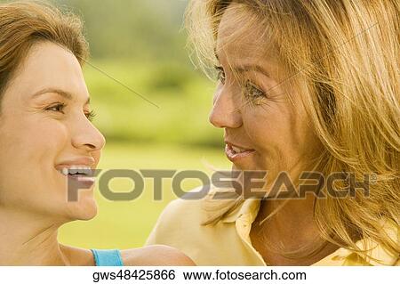 Close-up of a mature woman and a mid adult woman smiling View Large Photo Image Stock Photograph - Close-up of a mature woman and a mid adult woman smiling. Fotosearch