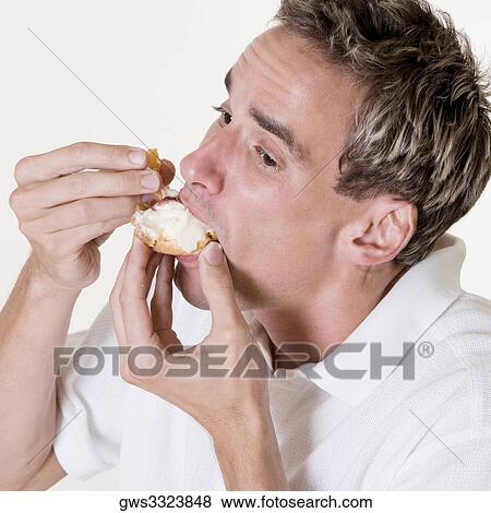 Close-up of a mid adult man eating a fruit tart View Large Photo Image Stock Photo - Close-up of a mid adult man eating a fruit tart. Fotosearch