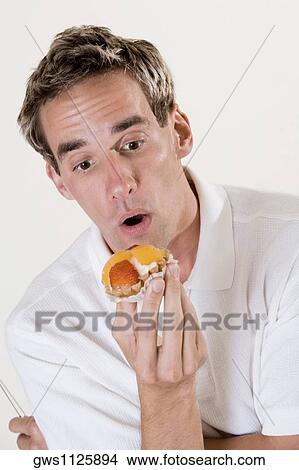 Close-up of a mid adult man holding a fruit tart View Large Photo Image Picture - Close-up of a mid adult man holding a fruit tart. Fotosearch
