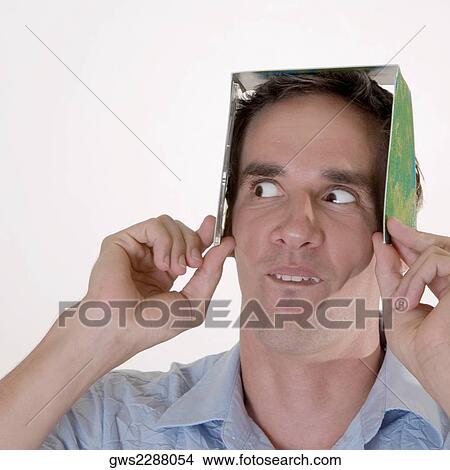 Close-up of a mid adult man holding a CD case on his head View Large Photo Image Picture - Close-up of a mid adult man holding a CD case on his head. Fotosearch