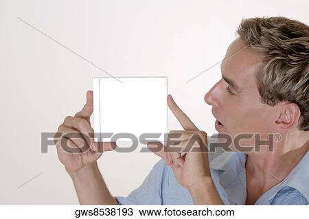 Close-up of a mid adult man holding a CD case View Large Photo Image Stock Image - Close-up of a mid adult man holding a CD case. Fotosearch