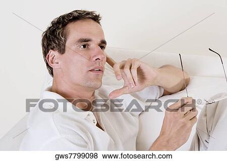 Close-up of a mid adult man holding his eyeglasses View Large Photo Image Stock Photo - Close-up of a mid adult man holding his eyeglasses. Fotosearch