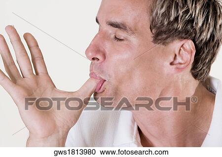 Close-up of a mid adult man licking his thumb View Large Photo Image Stock Image - Close-up of a mid adult man licking his thumb. Fotosearch