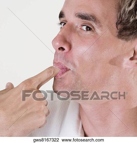 Close-up of a mid adult man licking his finger View Large Photo Image Stock Image - Close-up of a mid adult man licking his finger. Fotosearch