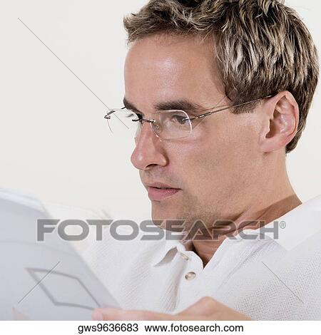 Close-up of a mid adult man reading a book View Large Photo Image Stock Image - Close-up of a mid adult man reading a book. Fotosearch