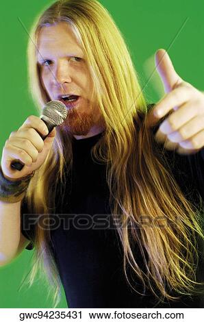 Stock Image - Close-up of a mid adult man singing into a microphone. Fotosearch