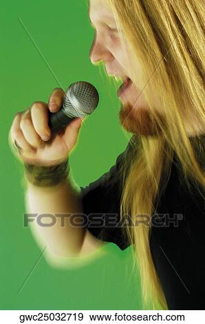 Close-up of a mid adult man singing into a microphone View Large Photo Image Stock Photo - Close-up of a mid adult man singing into a microphone. Fotosearch