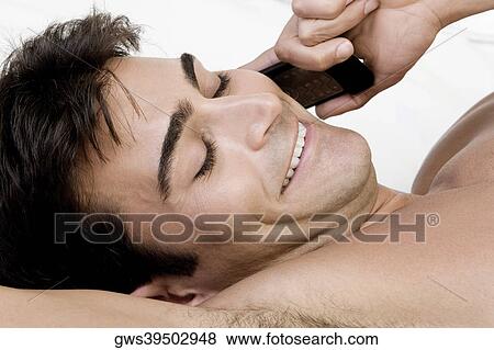 Close-up of a mid adult man talking on a mobile phone View Large Photo Image Stock Photo - Close-up of a mid adult man talking on a mobile phone. Fotosearch