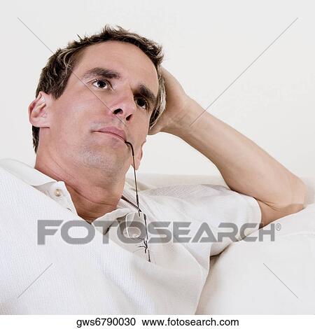 Stock Image - Close-up of a mid adult man with his hand on his head. Fotosearch