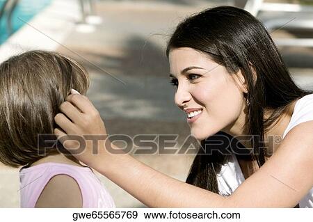 Close-up of a mother with her daughter smiling View Large Photo Image Stock Photo - Close-up of a mother with her daughter smiling. Fotosearch