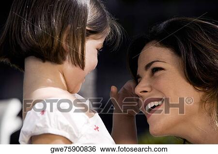 Stock Photograph - Close-up of a mother with her daughter smiling. Fotosearch