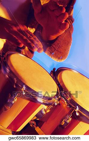Stock Image - Close-up of a musician playing the bongo. Fotosearch
