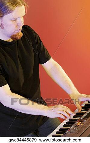 Stock Photo - Close-up of a musician playing the synthesizer. Fotosearch