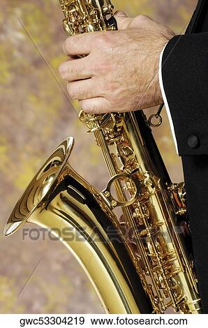 Close-up of a musician's hand holding a saxophone View Large Photo Image Stock Photo - Close-up of a musician's hand holding a saxophone. Fotosearch