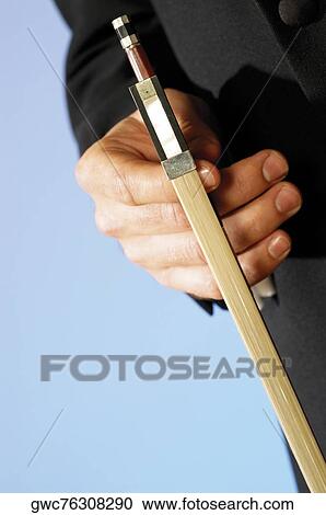 Stock Image - Close-up of a musician's hand holding the bow of a violin. Fotosearch