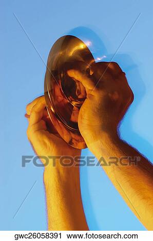 Stock Image - Close-up of a musician's hands playing the cymbals. Fotosearch