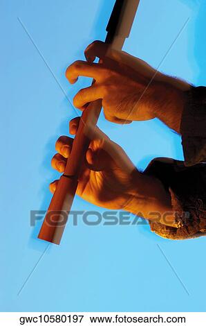 Stock Photo - Close-up of a musician's hands playing the flute. Fotosearch