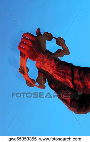 Stock Photography - Close-up of a musician's hands playing the tambourine. Fotosearch