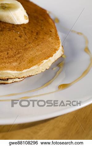 Stock Photograph - Close-up of a pancake with a banana slice on it. Fotosearch