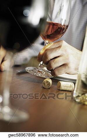 Stock Photograph - Close-up of a person's hand holding a glass of wine. Fotosearch