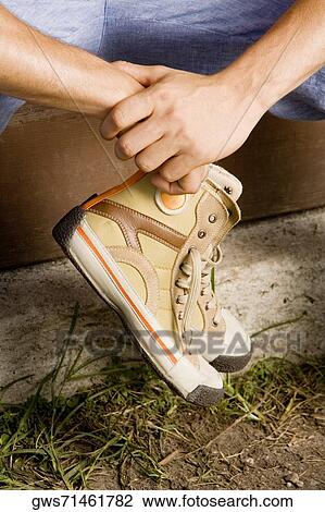 Close-up of a person's hands holding a pair of shoes View Large Photo Image Stock Image - Close-up of a person's hands holding a pair of shoes. Fotosearch