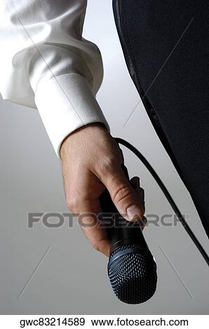 Close-up of a singer's hand holding a microphone View Large Photo Image Stock Photo - Close-up of a singer's hand holding a microphone. Fotosearch