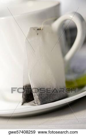 Close-up of a tea cup and a teabag in a saucer View Large Photo Image Stock Photo - Close-up of a tea cup and a teabag in a saucer. Fotosearch